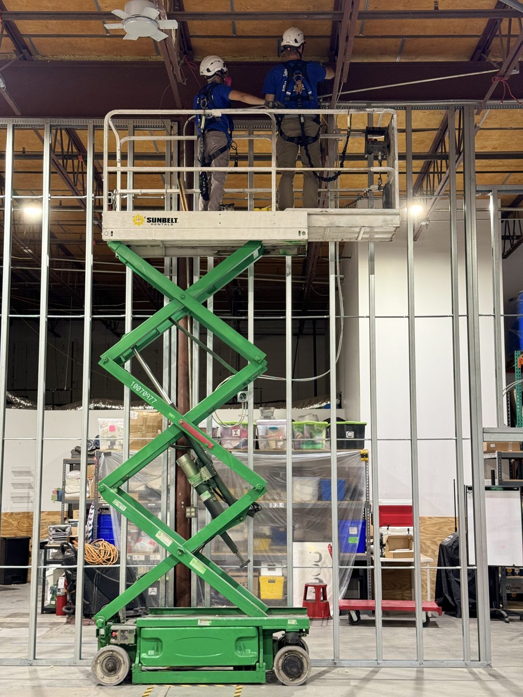Crew in harnesses on a scissor lift framing at height